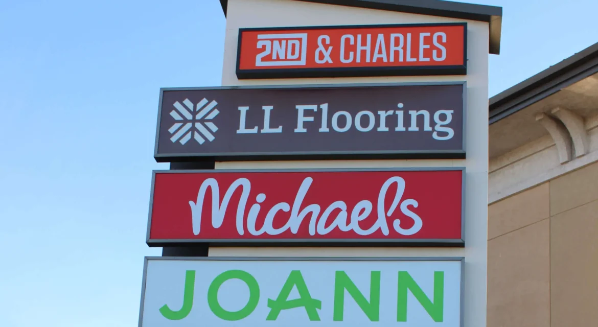 Light up sIgn of strip mall stores.