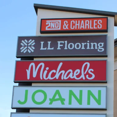 Light up sIgn of strip mall stores.
